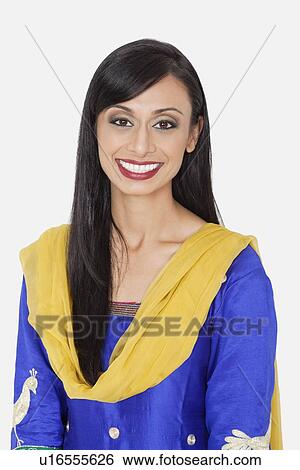 Stock Photograph - Portrait of pretty Indian woman in traditional wear smiling against gray background. Fotosearch