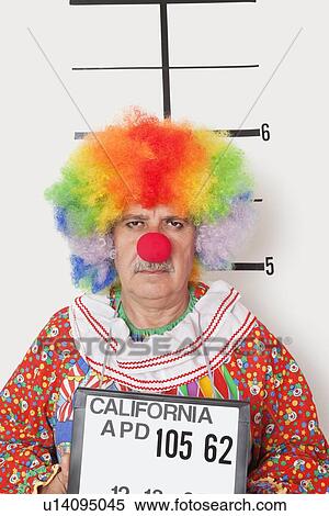 Stock Photography - Portrait of senior clown posing for mug shot. Fotosearch