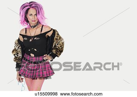 Portrait of senior female punk standing with hand on hip over gray background View Large Photo Image Stock Photo - Portrait of senior female punk standing with hand on hip over gray background. Fotosearch
