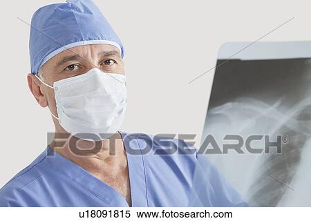 Portrait of senior male surgeon examining x-ray over gray background View Large Photo Image Stock Photography - Portrait of senior male surgeon examining x-ray over gray background. Fotosearch