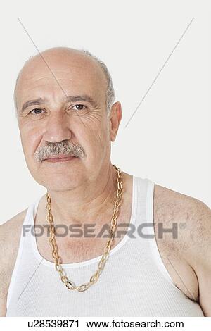 Stock Image - Portrait of senior man in vest with gold chain over gray background. Fotosearch