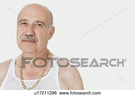 Stock Photograph - Portrait of senior man with gold chain over gray background. Fotosearch