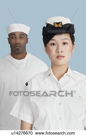 Portrait of serious female US Navy officer in front male sailor over light blue background View Large Photo Image Stock Image - Portrait of serious female US Navy officer in front male sailor over light blue background. Fotosearch