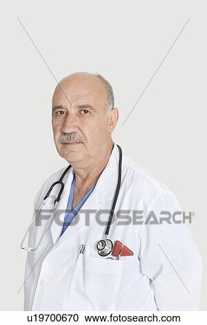 Portrait of serious senior medical practitioner over gray background View Large Photo Image Stock Image - Portrait of serious senior medical practitioner over gray background. Fotosearch