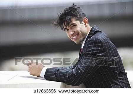 Stock Photograph - Portrait of smiling Indian businessman in pinstriped suit outdoors. Fotosearch