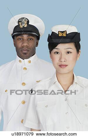 Stock Photo - Portrait of two US Navy officers over light blue background. Fotosearch