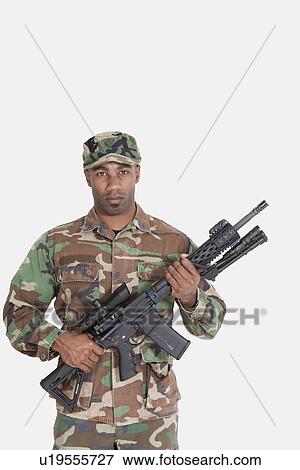 Stock Photo - Portrait of young African American US Marine Corps soldier with M4 assault rifle over gray background. Fotosearch