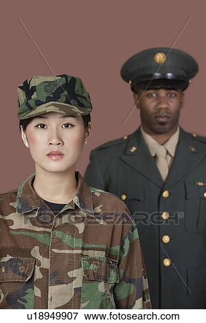 Stock Photo - Portrait of young female US Marine Corps soldier with male officer in background. Fotosearch