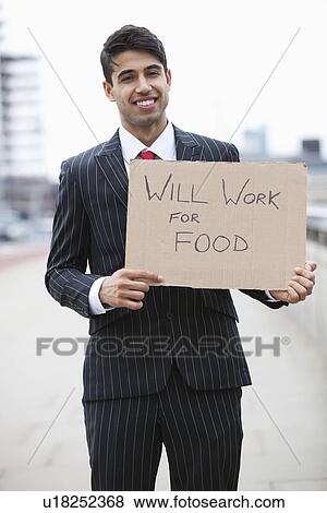 Stock Photo - Portrait of young Indian businessman holding 'Will Work for Food' sign. Fotosearch