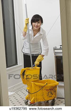 Portrait of young maidservant with mop View Large Photo Image Stock Photography - Portrait of young maidservant with mop. Fotosearch
