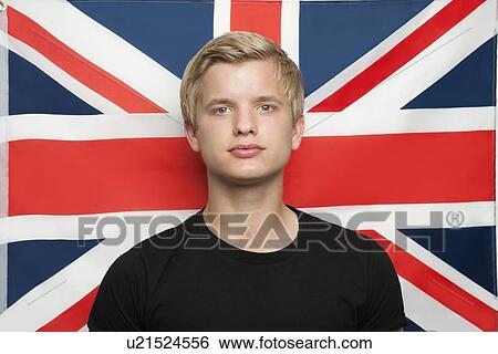 Portrait of young man against British flag View Large Photo Image Stock Photograph - Portrait of young man against British flag. Fotosearch