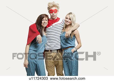 Portrait of young man in superhero costume and women wearing jumpsuits standing together against gray background View Large Photo Image Stock Image - Portrait of young man in superhero costume and women wearing jumpsuits standing together against gray background. Fotosearch
