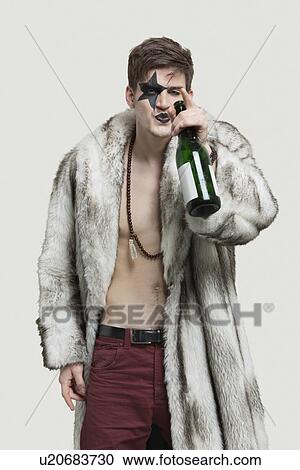 Portrait of young man with beer bottle over gray background View Large Photo Image Stock Image - Portrait of young man with beer bottle over gray background. Fotosearch