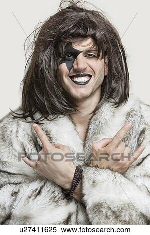 Portrait of young man with painted face making rebellious gestures over gray background View Large Photo Image Stock Photography - Portrait of young man with painted face making rebellious gestures over gray background. Fotosearch