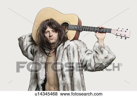 Stock Photo - Portrait of young trendy man with guitar over gray background. Fotosearch