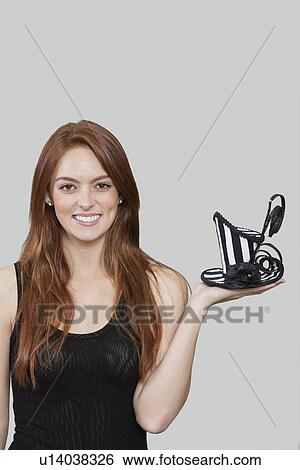 Portrait of young woman holding stylish hat against colored background View Large Photo Image Stock Photograph - Portrait of young woman holding stylish hat against colored background. Fotosearch