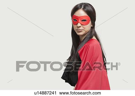 Portrait of young woman in superhero costume against gray background View Large Photo Image Stock Image - Portrait of young woman in superhero costume against gray background. Fotosearch