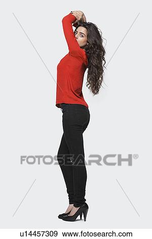 Profile view of a young woman standing over gray background View Large Photo Image Stock Photo - Profile view of a young woman standing over gray background. Fotosearch