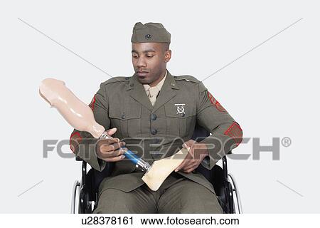 Sad US military officer in wheelchair holding prosthesis foot over gray background View Large Photo Image Stock Image - Sad US military officer in wheelchair holding prosthesis foot over gray background. Fotosearch