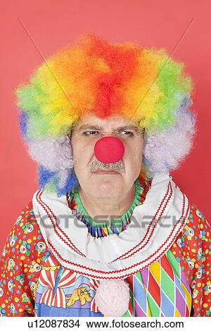 Senior male clown frowning over red background View Large Photo Image Picture - Senior male clown frowning over red background. Fotosearch