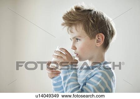 Side view of a young boy drinking milk View Large Photo Image Stock Photo - Side view of a young boy drinking milk. Fotosearch