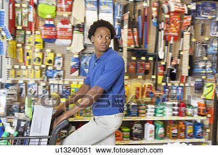 Stock Image - Side view of African American in hardware store. Fotosearch