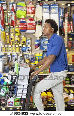 Side view of African American man with shopping cart at hardware store View Large Photo Image Stock Image - Side view of African American man with shopping cart at hardware store. Fotosearch