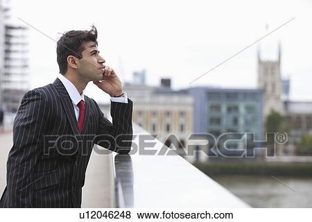 Side view of serious Indian businessman on call outdoors View Large Photo Image Stock Photo - Side view of serious Indian businessman on call outdoors. Fotosearch