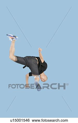 Teenage boy break dancing over blue background View Large Photo Image Stock Photograph - Teenage boy break dancing over blue background. Fotosearch