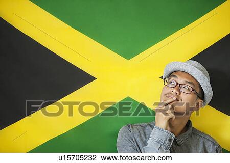 Stock Image - Thoughtful man against Jamaican flag. Fotosearch