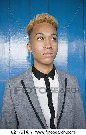 Trendy teenage boy looking away against wood paneling View Large Photo Image Stock Photo - Trendy teenage boy looking away against wood paneling. Fotosearch