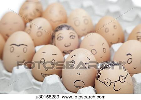 Stock Photo - Various facial expressions painted on brown eggs in egg carton. Fotosearch