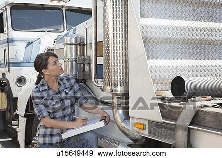 Woman inspecting flatbed truck View Large Photo Image Stock Photo - Woman inspecting flatbed truck. Fotosearch