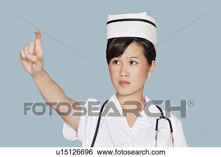 Young female doctor using transparent screen over light blue background View Large Photo Image Stock Photograph - Young female doctor using transparent screen over light blue background. Fotosearch
