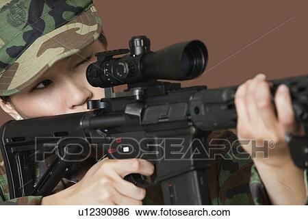Young female US Marine Corps soldier aiming M4 assault rifle over brown background View Large Photo Image Stock Photograph - Young female US Marine Corps soldier aiming M4 assault rifle over brown background. Fotosearch