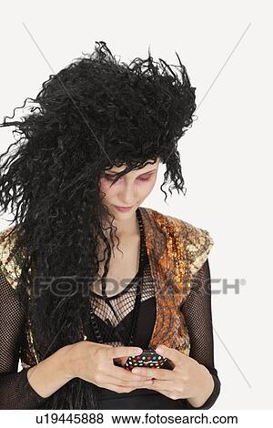 Young Goth woman with teased hair texting on cell phone over gray background View Large Photo Image Stock Photo - Young Goth woman with teased hair texting on cell phone over gray background. Fotosearch