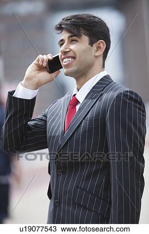 Young Indian businessman communicating on cell phone View Large Photo Image Stock Image - Young Indian businessman communicating on cell phone. Fotosearch