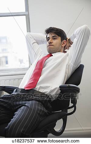 Young Indian businessman contemplating while sitting in office chair View Large Photo Image Stock Photo - Young Indian businessman contemplating while sitting in office chair. Fotosearch