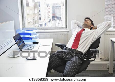 Stock Photograph Of Young Indian Businessman Relaxing In Chair At Stock Photograph Young Indian Businessman Relaxing In Chair At Office Desk Fotosearch Search