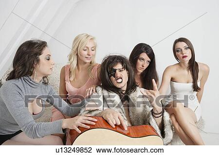 Young male guitarist with a cool gesture amid female group View Large Photo Image Stock Image - Young male guitarist with a cool gesture amid female group. Fotosearch