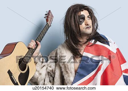 Young man with British flag holding guitar against light blue background View Large Photo Image Stock Image - Young man with British flag holding guitar against light blue background. Fotosearch