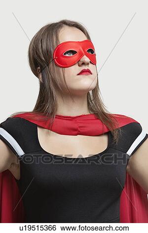 Young woman in superhero costume looking up over gray background View Large Photo Image Stock Photograph - Young woman in superhero costume looking up over gray background. Fotosearch
