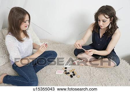 Young women playing cards while sitting on fur sofa View Large Photo Image Stock Image - Young women playing cards while sitting on fur sofa. Fotosearch