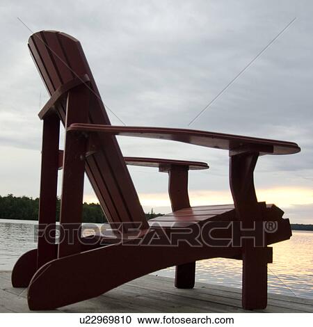 Adirondack chair on a pier at the lakeside, Lake of the Woods, Ontario, Canada View Large Photo Image Stock Image - Adirondack chair on a pier at the lakeside, Lake of the Woods, Ontario, Canada. Fotosearch