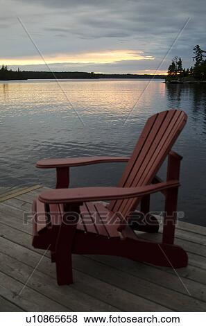 Adirondack chair on a pier at the lakeside, Lake of the Woods, Ontario, Canada View Large Photo Image Stock Photo - Adirondack chair on a pier at the lakeside, Lake of the Woods, Ontario, Canada. Fotosearch