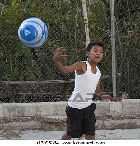 Picture - Boy playing with a soccer ball, Colonia Bethania, Guatemala City, Guatemala. Fotosearch