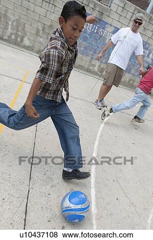 Stock Photo - Boy playing with a soccer ball, Colonia Bethania, Guatemala City, Guatemala. Fotosearch