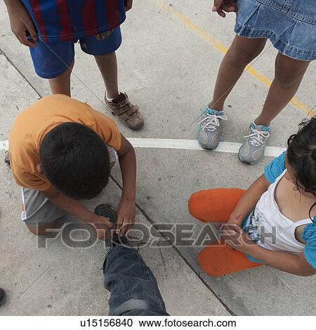 Boy tying shoelace of his friend, Colonia Bethania, Guatemala City, Guatemala View Large Photo Image Stock Image - Boy tying shoelace of his friend, Colonia Bethania, Guatemala City, Guatemala. Fotosearch