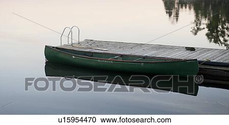 Stock Image - Canoe moored at a pier in a lake, Lake of the Woods, Ontario, Canada. Fotosearch