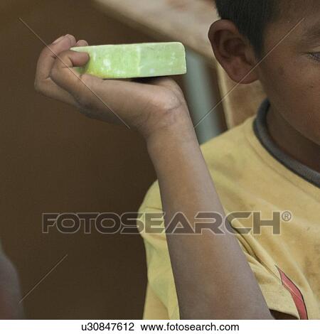 Stock Image - Close-up of a boy holding a soap bar, San Jose Pinula, Guatemala City, Guatemala. Fotosearch